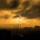 Image: a industrial emissions envelope a metropolitan area at dusk. Image by Free-Image of Pixabay. End ID.